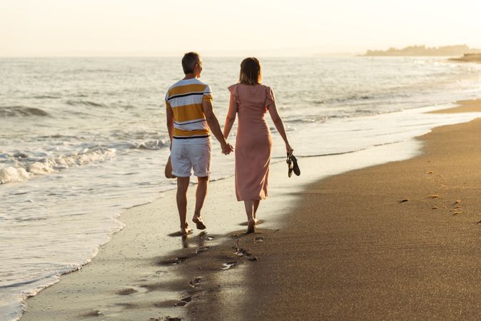 Adult couple walking towards sea