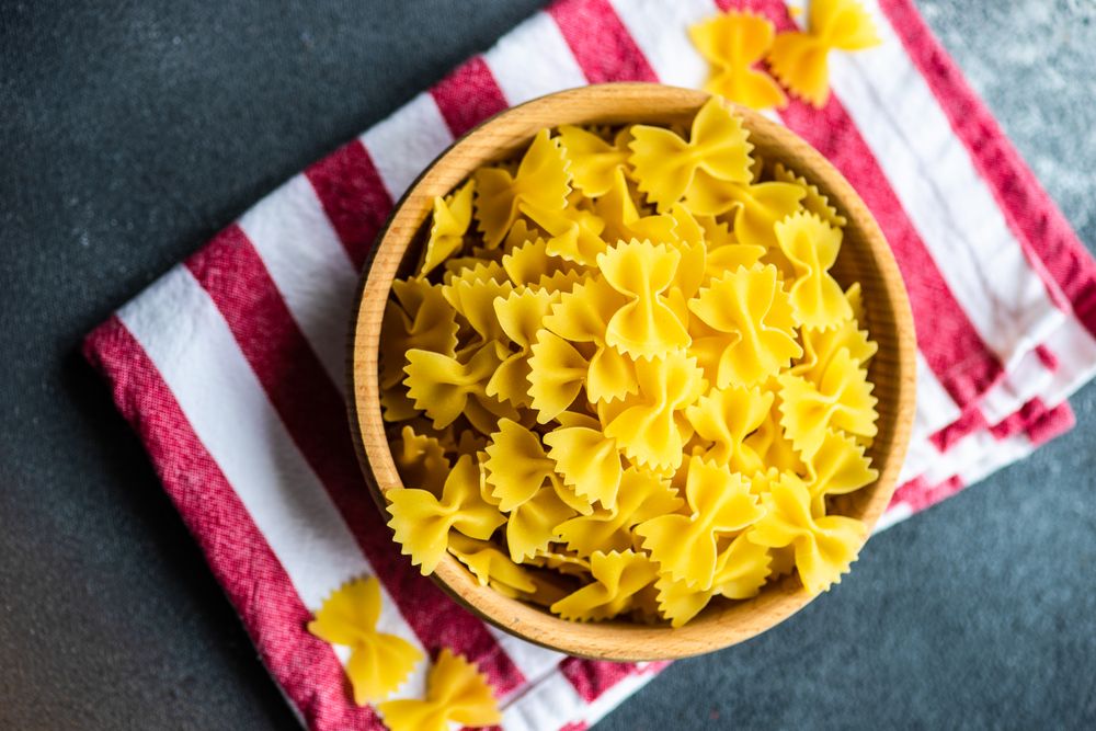 Uncooked bowl of bow tie pasta with copy space