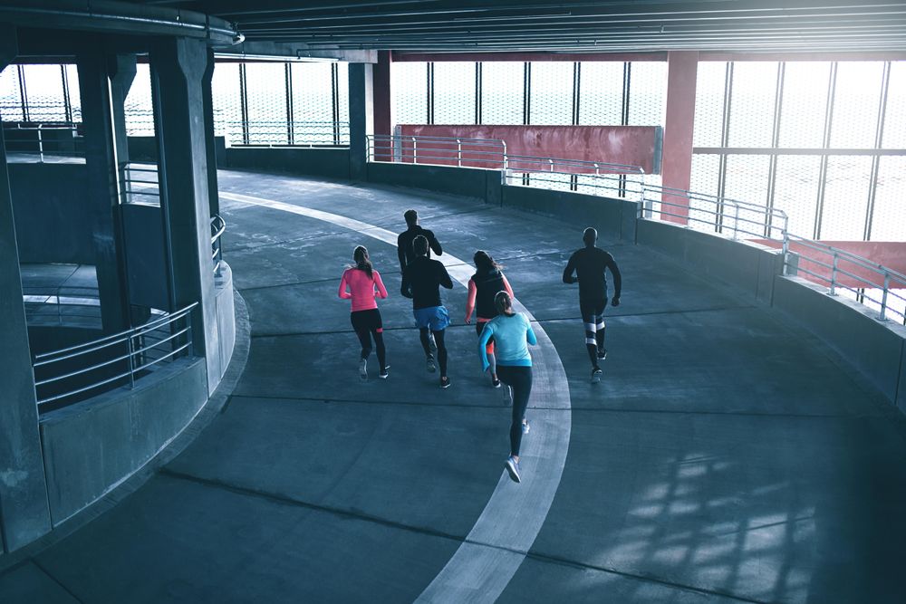 Picture looking down at people running in concrete space