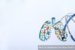 Cut out lung shape with pills underneath with doctor’s stethoscope and copy space 0Ly1V5