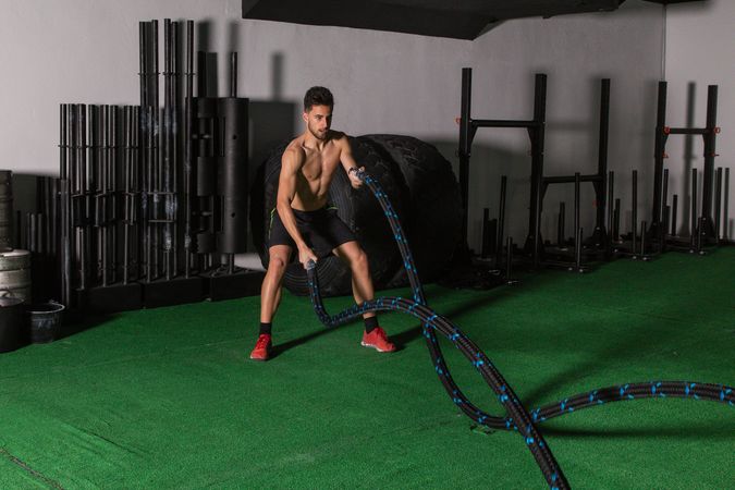 Man training with ropes in gym