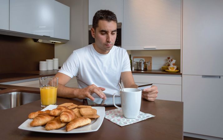 Man with credit card and digital tablet over breakfast