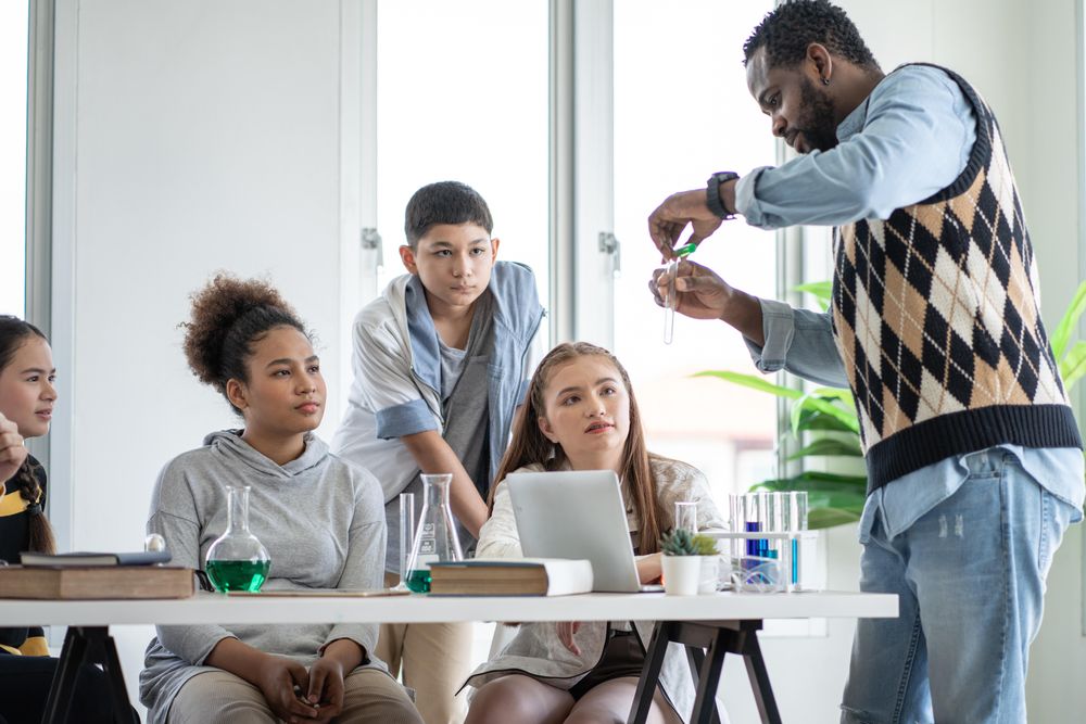 Students listening teacher holding test tube