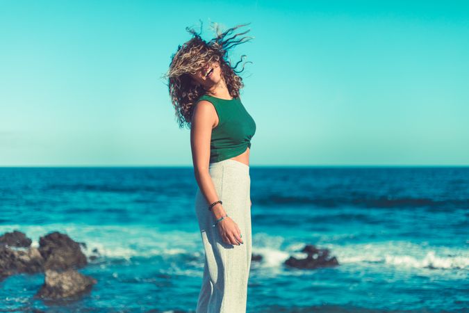Stylish woman standing near sea