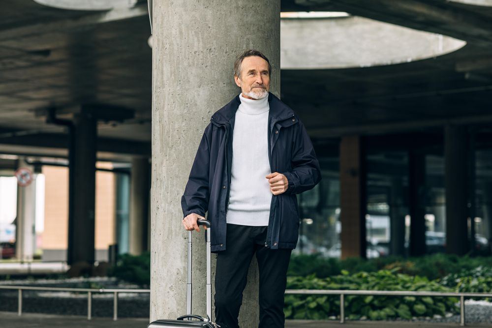 Stylish mature tourist standing outdoors in underpass