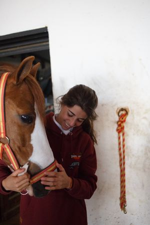 Girl with adorable pony in hat