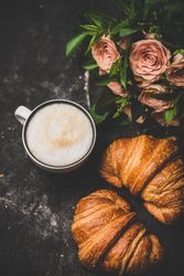 Coffee with croissants and pink roses