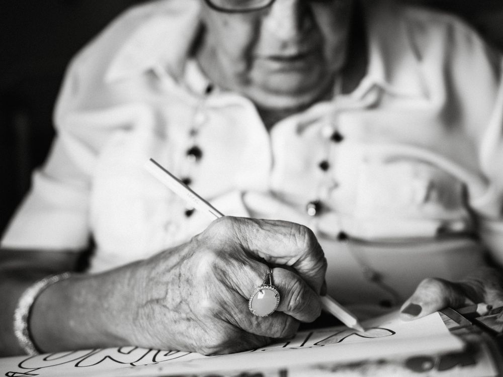 Mature female drawing on paper in apartment