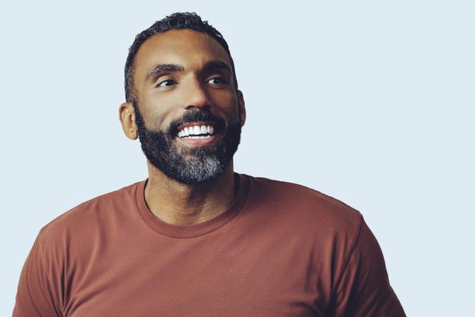 Head shot of laughing Black male looking up in grey studio