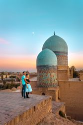 Couple embracing each other near Islamic building