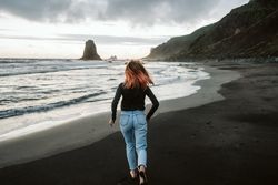 Barefoot female running near waving sea