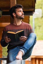Pensive man chilling on terrace with book