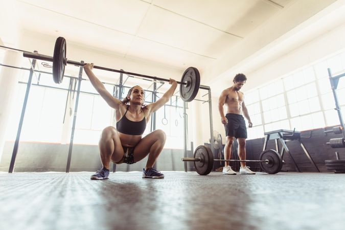 Woman performing deadlift exercise with weight bar