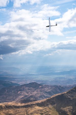 Small aircraft flying over mountains