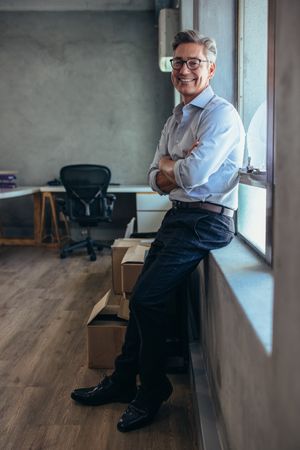 Male entrepreneur standing in office with his arms crossed