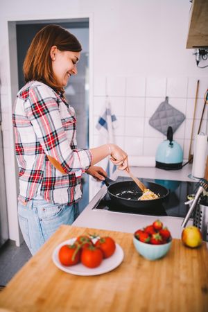 Woman cooking eggs in a pan