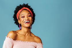 Studio shoot of joyful Black woman smiling at the camera