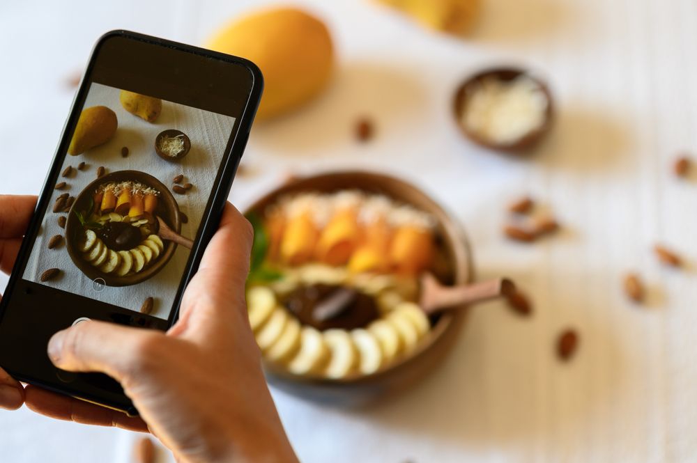 Crop person taking photo of healthy breakfast