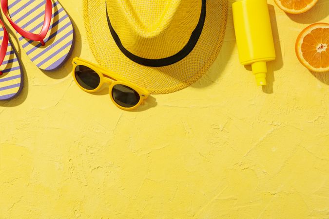 Summer vacation accessories on yellow background, space for text