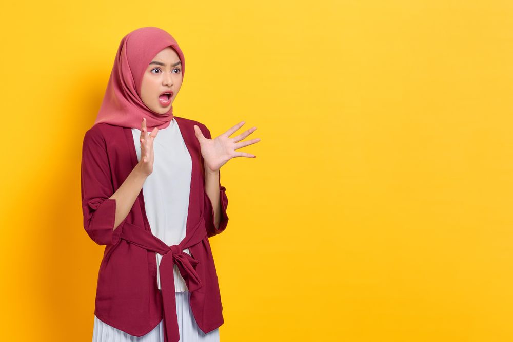 Incredulous woman in red headscarf looking to the side surprised