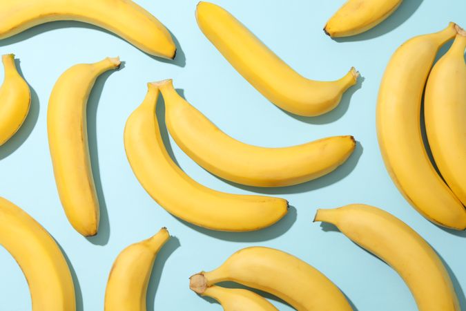 Banana clusters on blue background. Fresh fruit