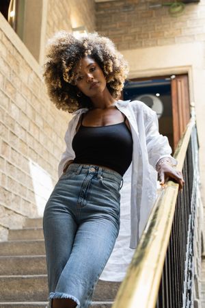 Black woman standing near railing of stairway