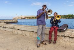 Havana, Cuba - November, 22 2012: Black men playing trombones on embankment