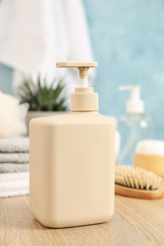Bottle for liquid soap on wooden table. Personal hygiene concept