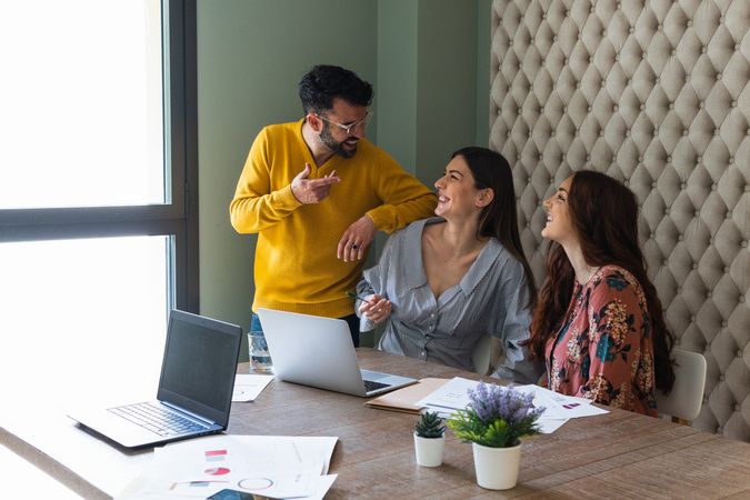 Joyful colleagues discussing project in modern workspace