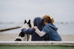 Kids hugging dog on beach