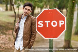 Man leaning against stop sign in park 5ke6Db