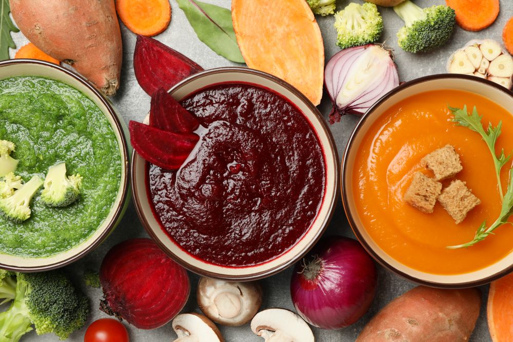 Close up of three multi-colored soups, top view