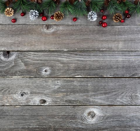 Christmas fir branches and silver gold pinecones on old wooden boards