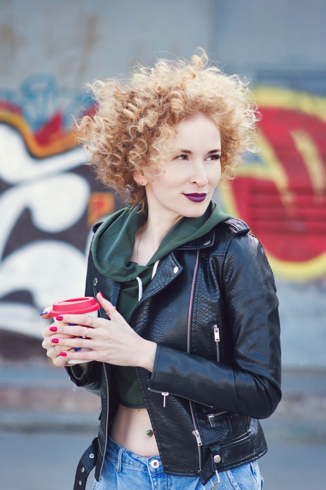 Curly haired woman in leather jacket outdoors