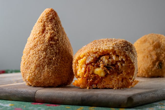 Traditional Sicilian "arancino" or "arancina" with meat filling on wooden board