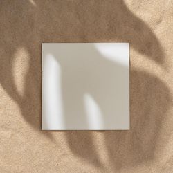 Sand with palm leaf shadows and central square