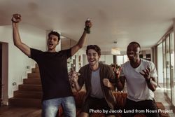 Three friends jumping in excitement while watching television 0Jow85