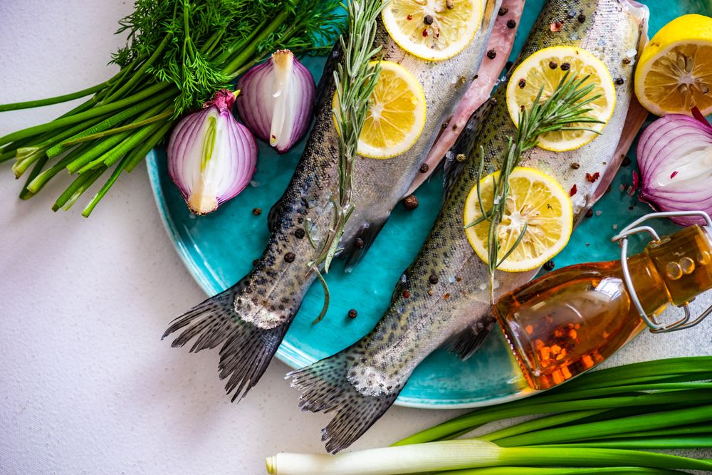 Uncooked trout fish and vegetables ready for cooking