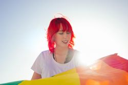 Young woman holding rainbow flag
