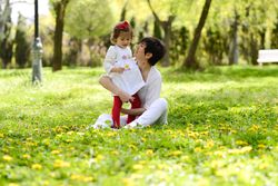 Happy mother sitting with daughter in park