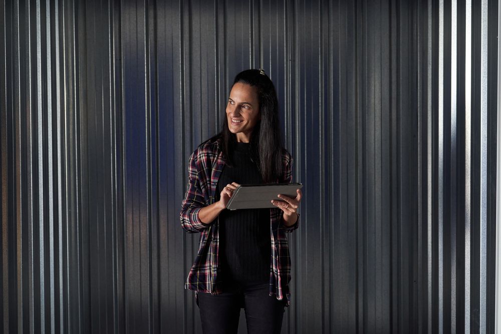 Delighted woman browsing tablet near container