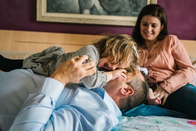 Happy family having fun in bedroom
