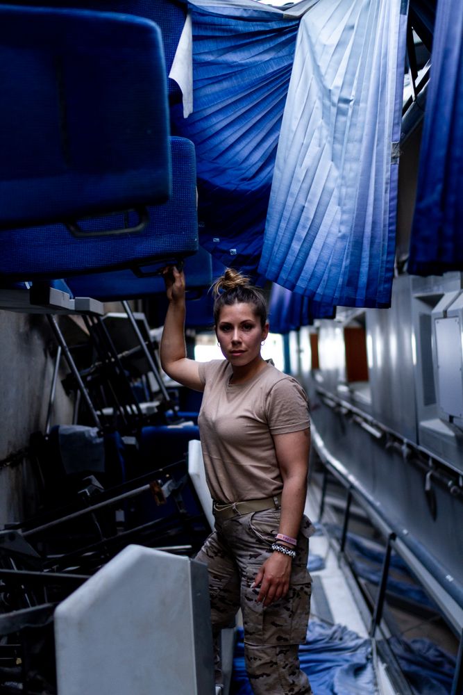 Military woman looking at camera inside vehicle