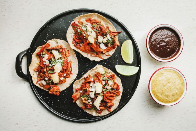 Pepper and lime near tacos al pastor and sauces