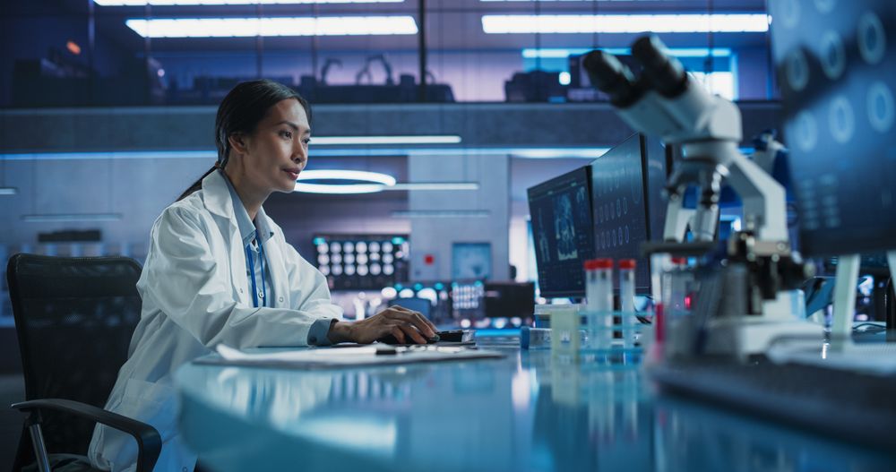 Hospital Research Center Laboratory: Asian Female Medical Scientist Using Computer with Brain MRI Images.