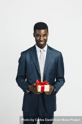 Professional Black man holding a wrapped present bEn310