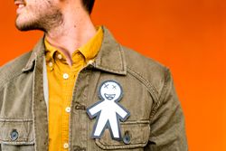 Smiling man with funny paper toy on jean jacket
