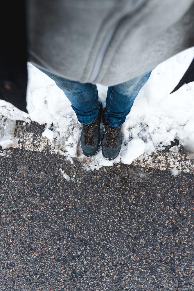 Faceless person standing on snowy road