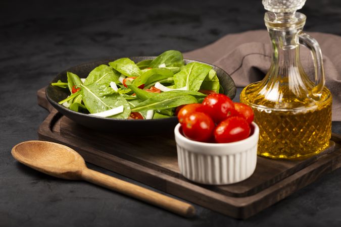 Arugula salad with tomatoes on dark background.