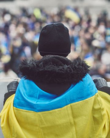 London, England, United Kingdom - March 5 2022: Back of man draped in Ukrainian flag